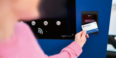 Vrouw met roze trui scant Q8  electric kaart aan Laadpunt